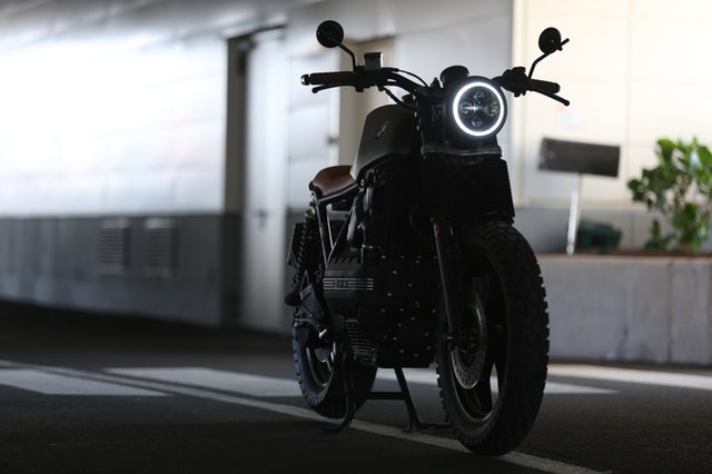 Čierna motorka so zapáleným svetlom v podzemnej garáži